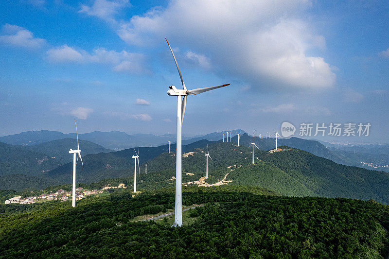 风力涡轮机和阳光山上的村庄