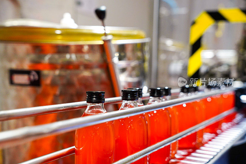 工业工厂中红色饮料的制造、装瓶和贴标过程