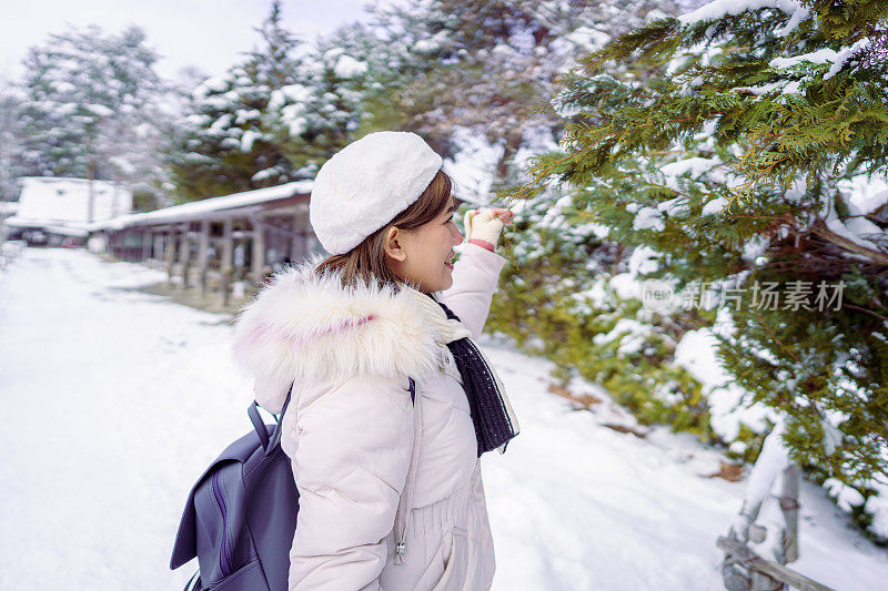 美丽的女游客享受他们的日本之旅在雪的冬天