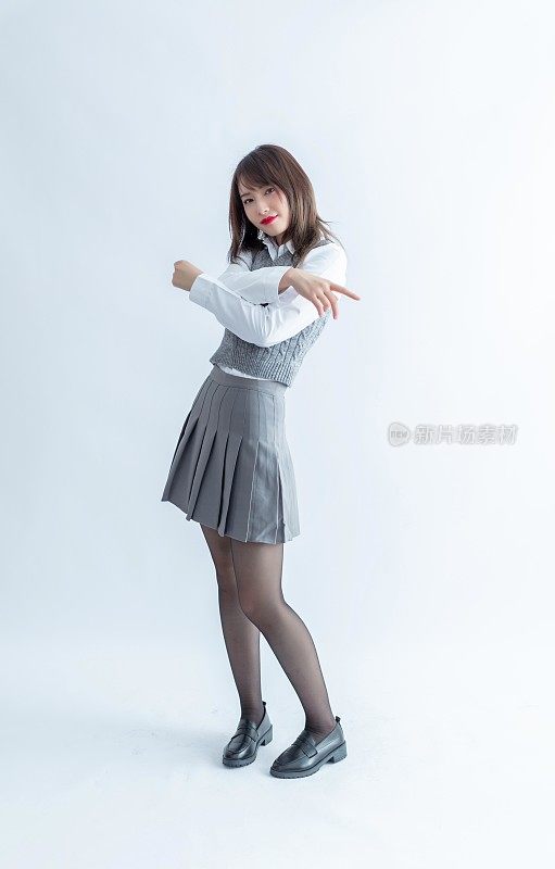 穿着灰色裙子制服的亚洲女学生高兴地跳舞