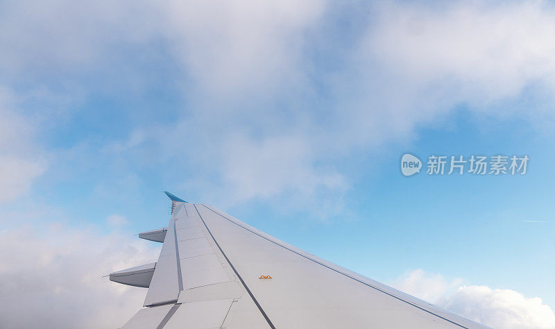 飞机的翅膀在蓝天上的背景文字空间。乘飞机旅行的概念。