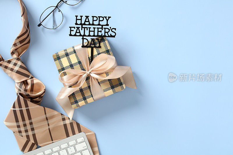 复古礼盒与文字快乐父亲节，领带，眼镜，键盘在蓝色背景。平的。俯视图