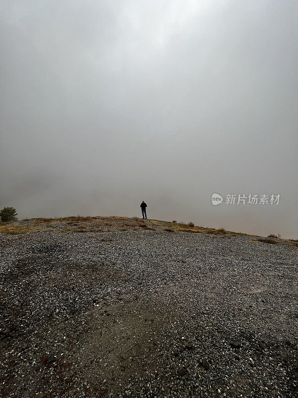 一个男人的剪影在灰色的雾的背景。