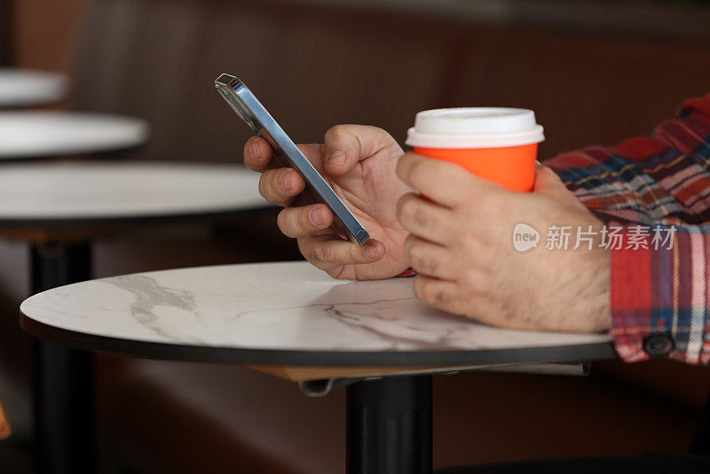 男子在咖啡馆使用智能手机