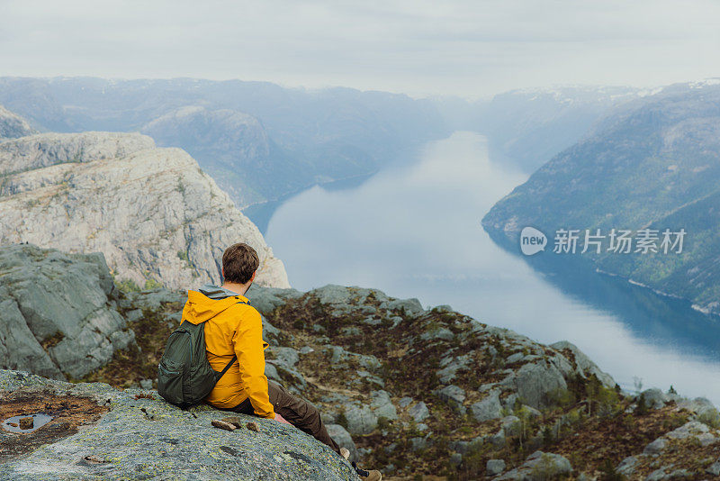 一个快乐的人从挪威风景优美的吕瑟峡湾俯瞰风景