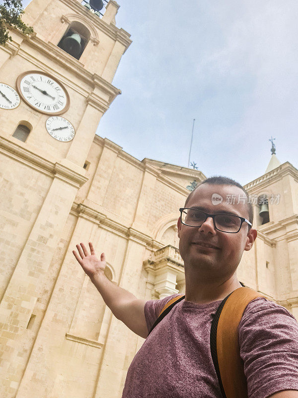 一名年轻人在马耳他瓦莱塔圣约翰大教堂前自拍