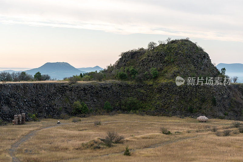 废弃的玄武岩采石场，背景是山脉