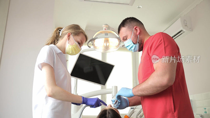 在现代诊所里，牙医和助手治疗牙齿。无痛牙科治疗
