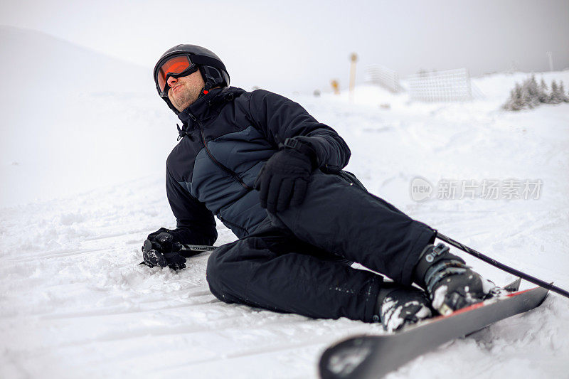 滑雪者在结冰的地形上失去平衡