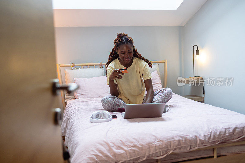 年轻的非裔美国女人在床上网购
