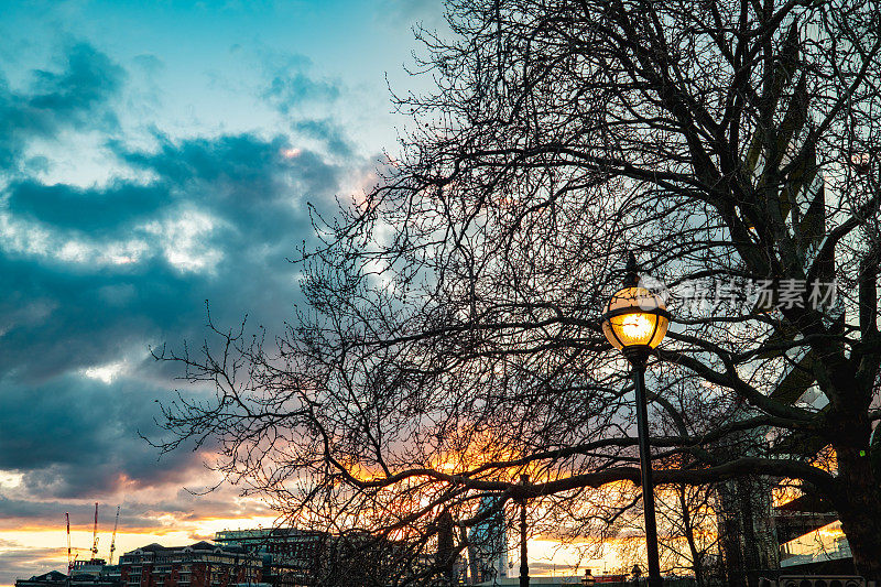 旧的老式灯柱在夕阳天空的背景