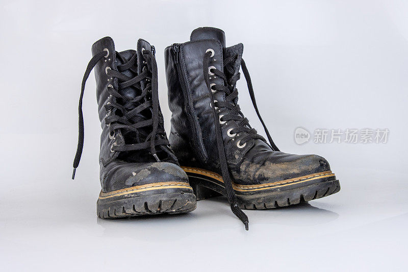 旧的使用过的破黑皮革军队蕾丝靴子。时髦的秋季靴子。时尚的女士，男士，男女皆宜的垃圾靴子与鞋带。高军鞋孤立在白色背景。平的。本空间