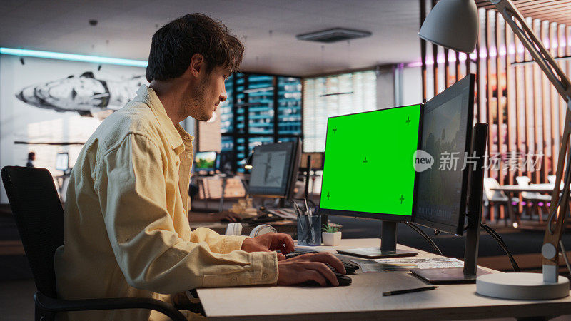 创意高加索人的肖像坐在桌子上使用桌面电脑与模拟绿屏铬。在游戏设计初创公司工作的男性关卡设计师，创造沉浸式游戏玩法