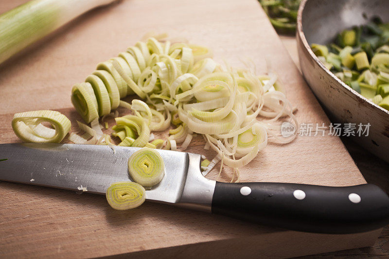 用刀在砧板上切韭菜