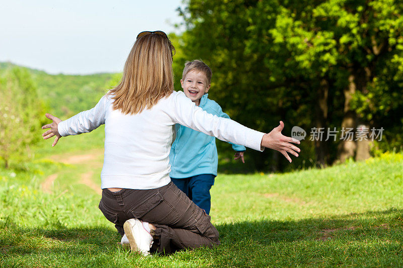 妈妈和她的儿子在公园外面玩