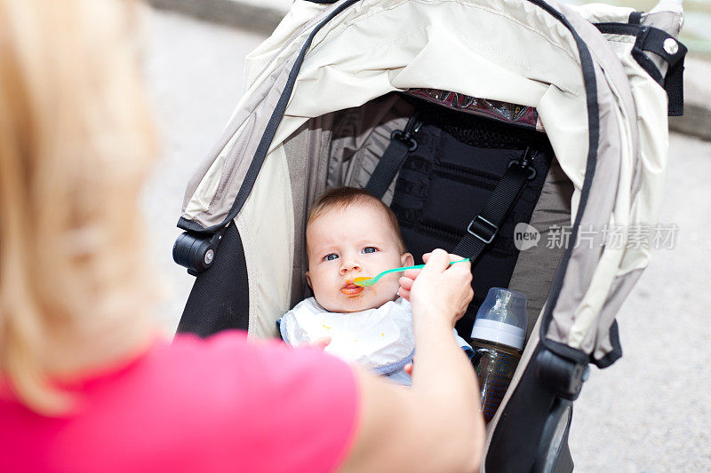 母亲在外面的婴儿车里给婴儿喂奶