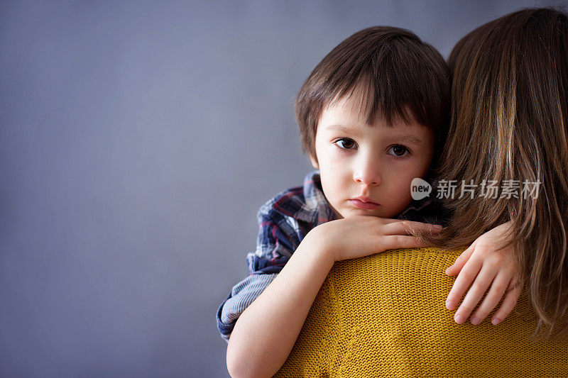 可怜的小男孩，在家里拥抱他的妈妈