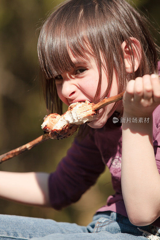 小女孩吃烤肉串