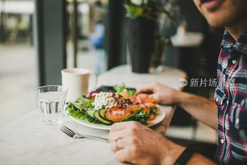 一个男人在咖啡厅吃午饭。