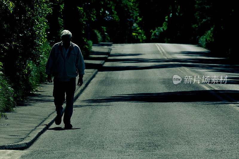 孤独的老人独自走在空旷的路上
