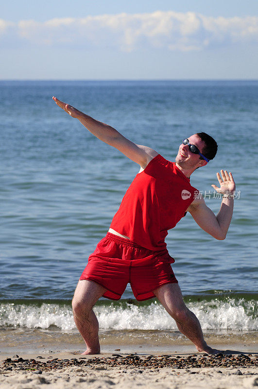 穿着红色泳衣在海滩上冲浪的家伙。