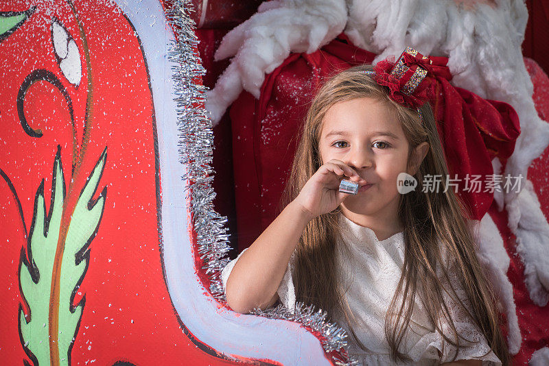 快乐的小女孩与圣诞车和圣诞鹿
