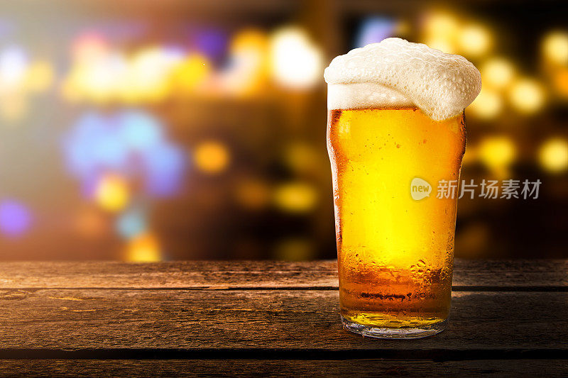 一杯啤酒在一个酒吧的桌子上模糊的散焦背景