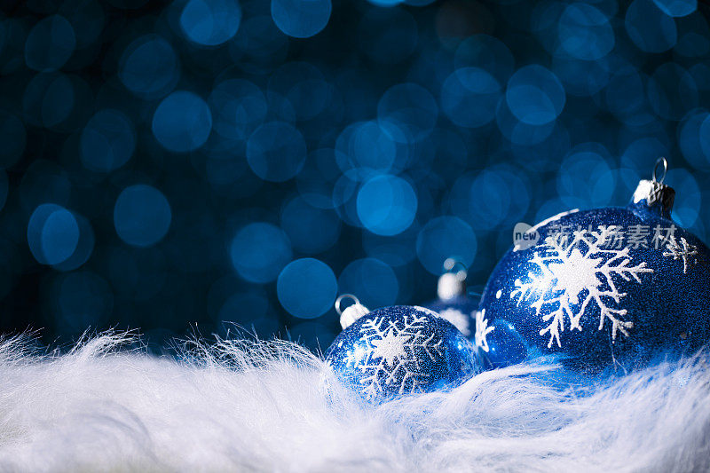 白色毛皮上的蓝色圣诞装饰品。雪花雪花寒假