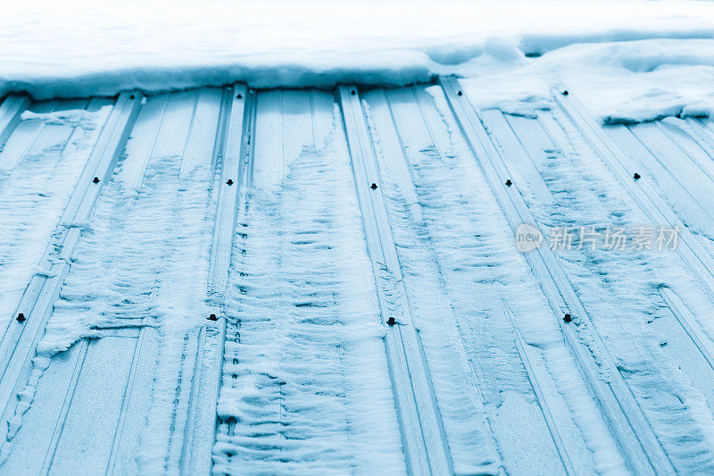 瓦楞钢屋顶上融化的冰雪