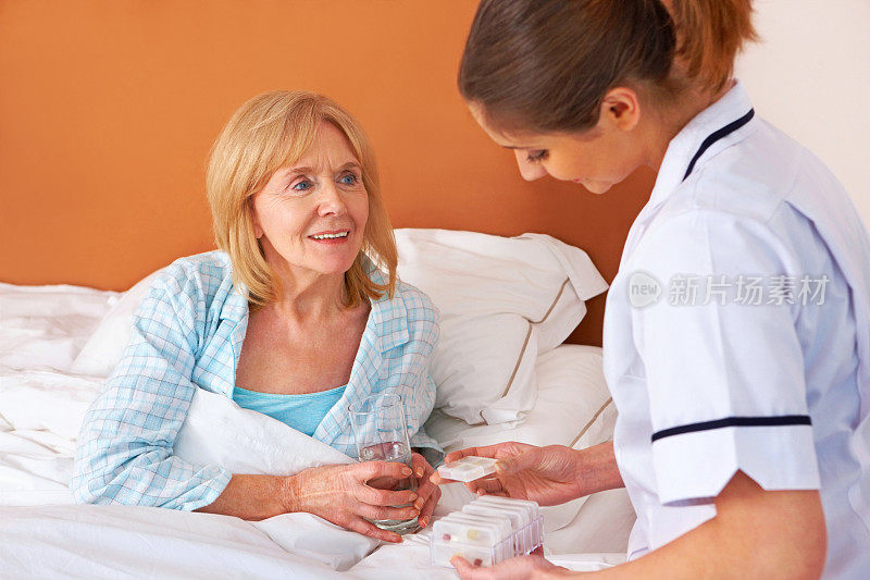 年轻护士给老年病人吃药