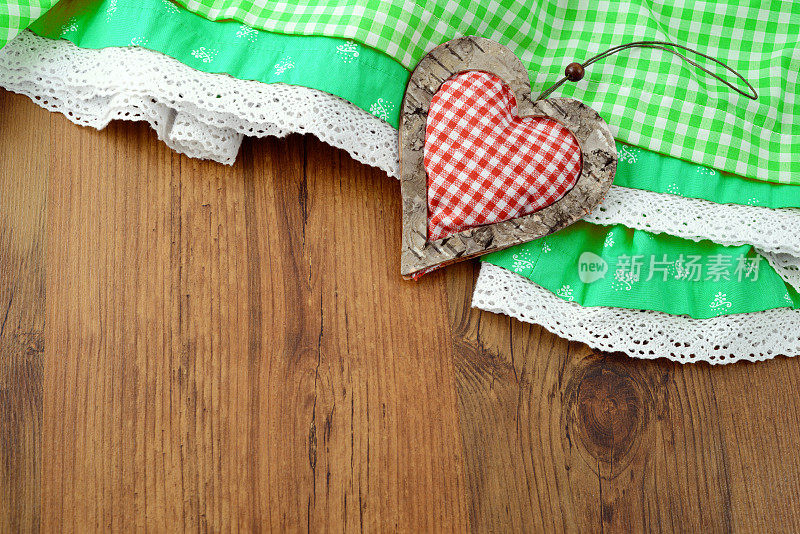 绿色的巴伐利亚啤酒节围裙放在心形的木桌上