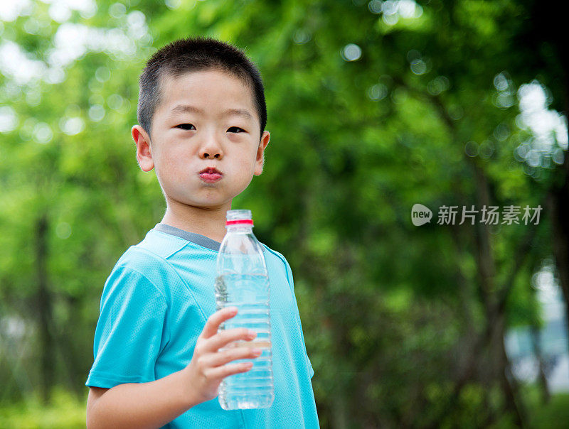亚洲小男孩在户外喝水