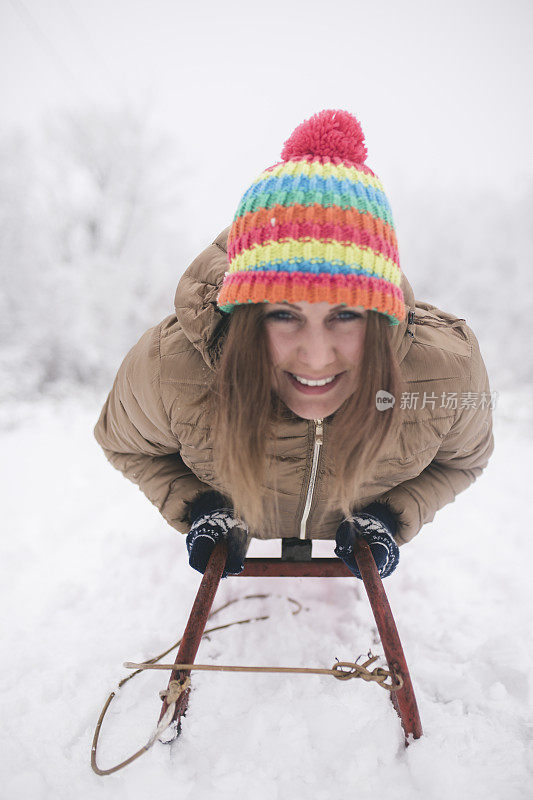 年轻女子在深雪中玩雪橇