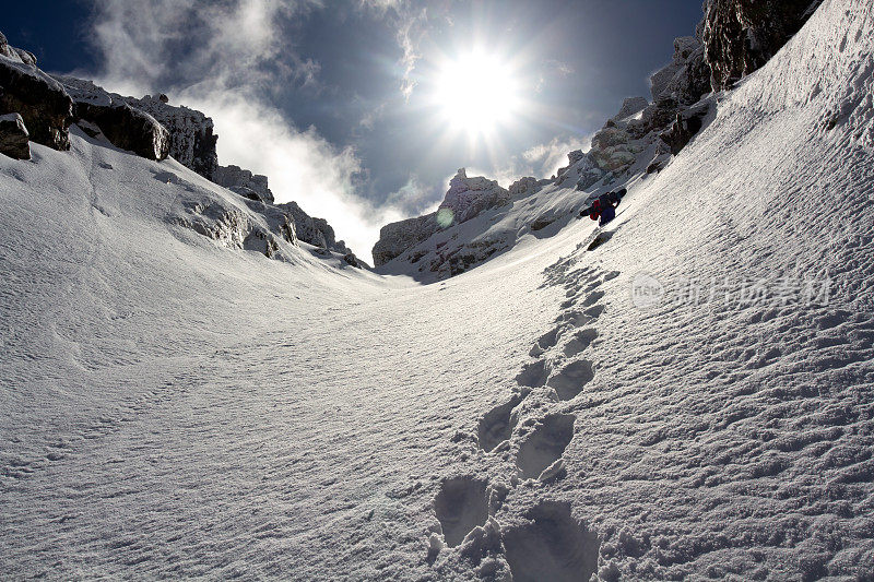 大雪过后，搭便车的人爬上陡峭的悬崖