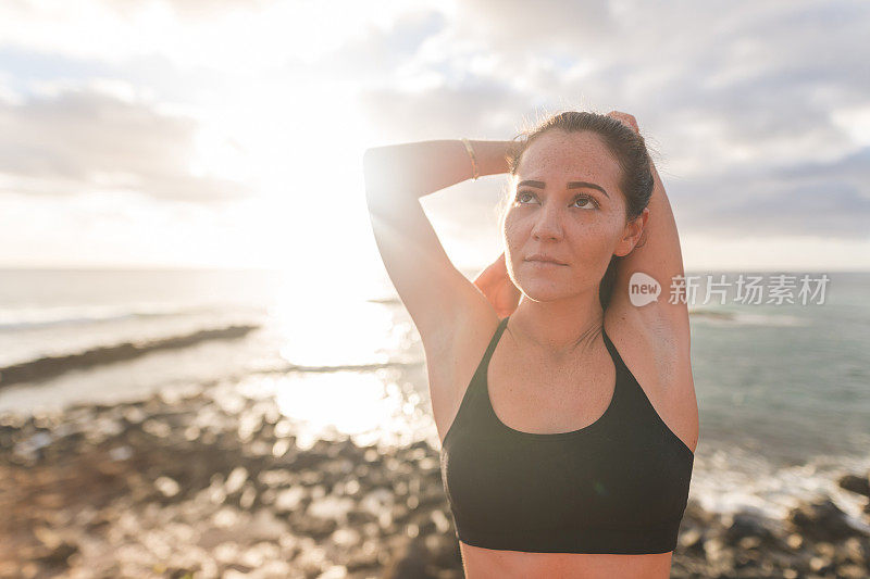 年轻的欧亚混血女子在夏威夷海岸线跑步后休息