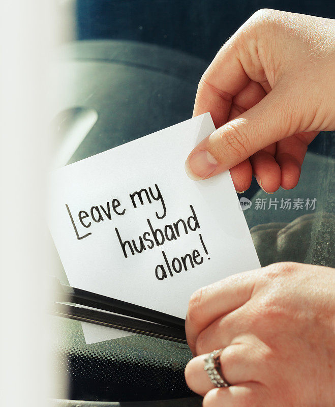 手上放着一张愤怒的纸条:“离我丈夫远点!”的挡风玻璃