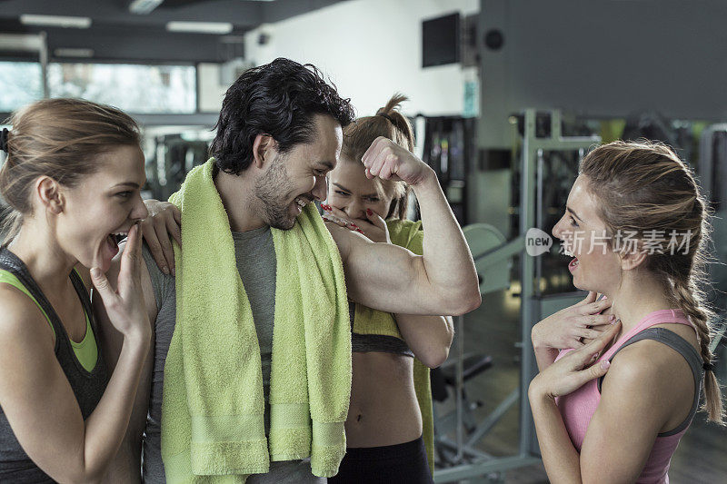 三个女人在健身房欣赏男人的肌肉