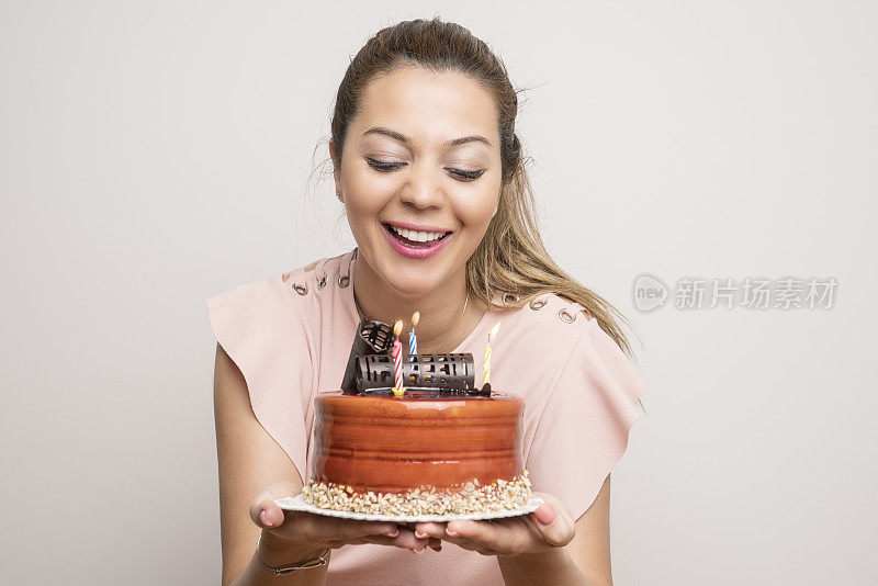 年轻女子用蛋糕庆祝生日