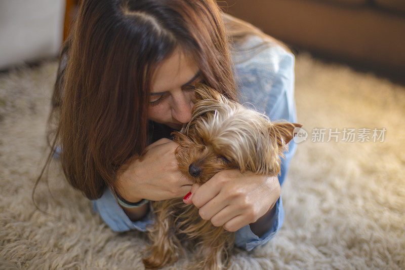 一个年轻的女人抚摸着她的狗