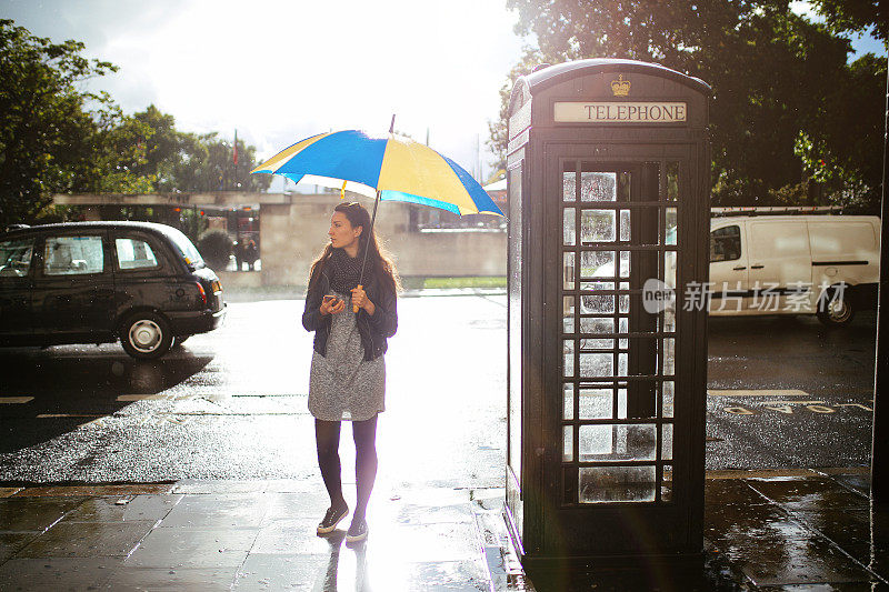 英国伦敦，一名年轻女子在街上叫出租车