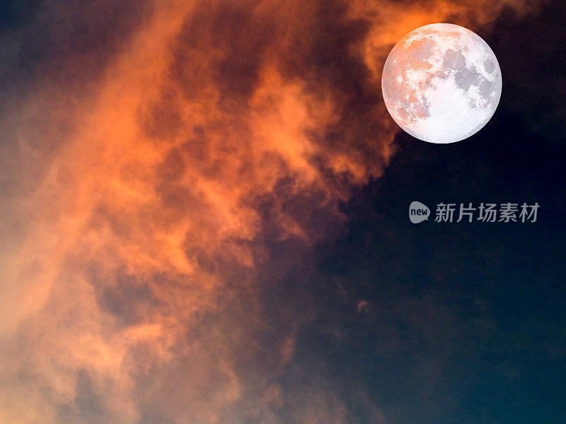 黑暗天空中的超级月亮和红色的软云