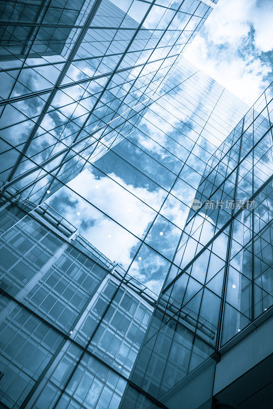 当代玻璃摩天大楼反映了蓝色的天空