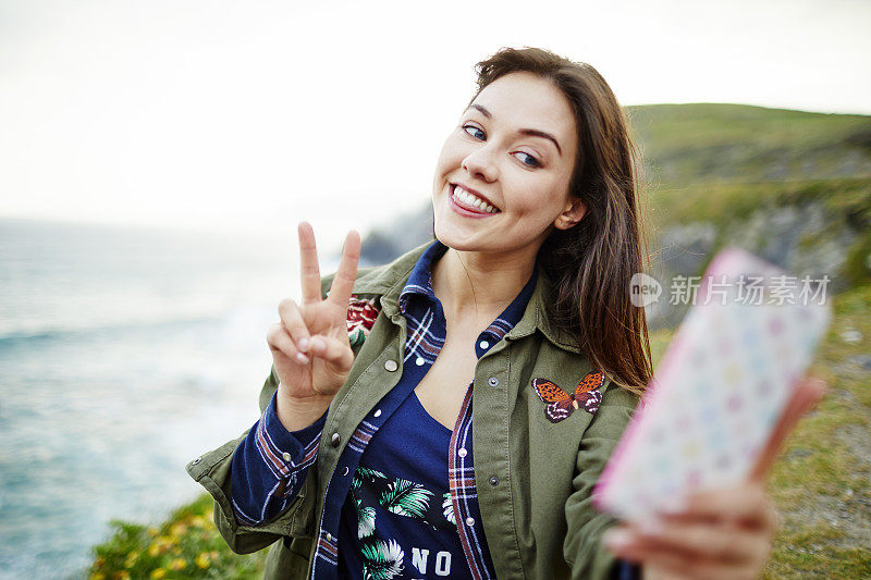 在山上用智能手机自拍的女性