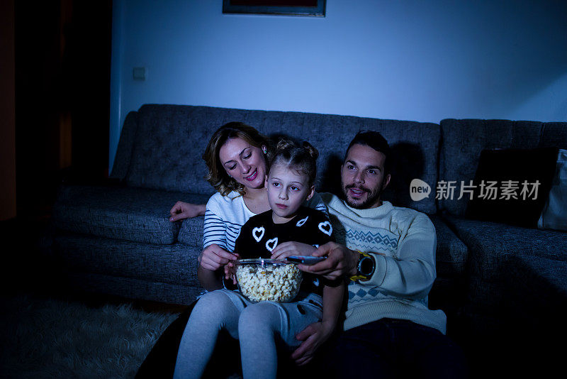 一家人一边看电视一边吃爆米花