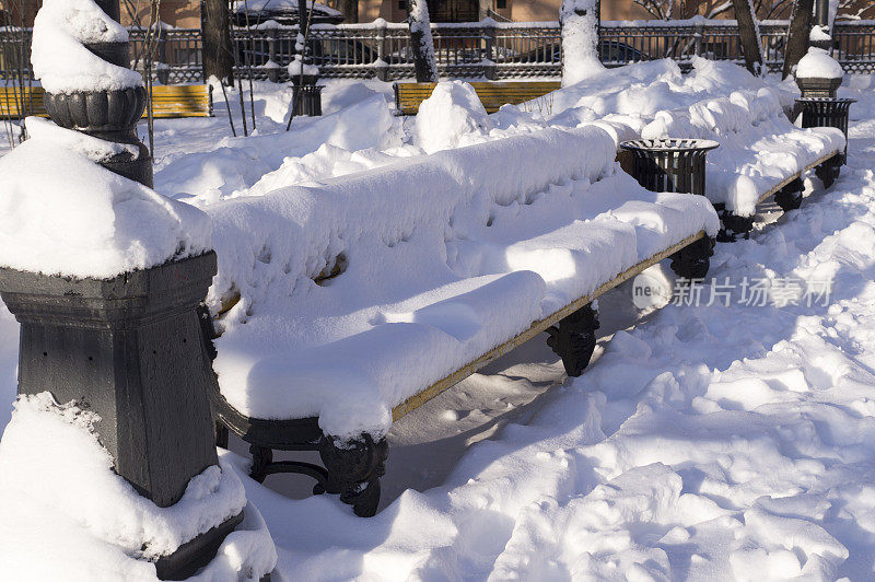 冬天的早晨，长凳上覆盖着雪。背景、自然。