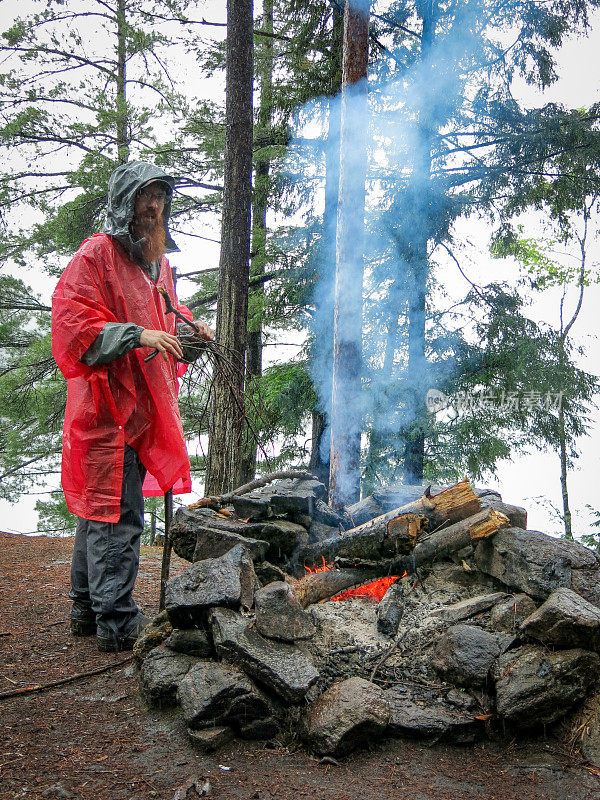 胡子眼镜男，红雨夹克，照看营火