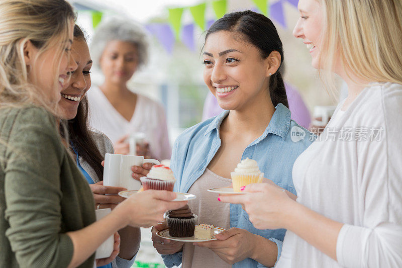 一群女人在慈善糕点义卖会上买纸杯蛋糕