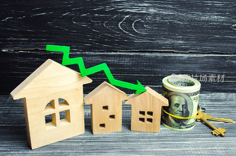 绿色箭头向下的房子。房地产价格的下降。低能效，抵押贷款利息下降。购房需求减少。公用事业价格低廉。