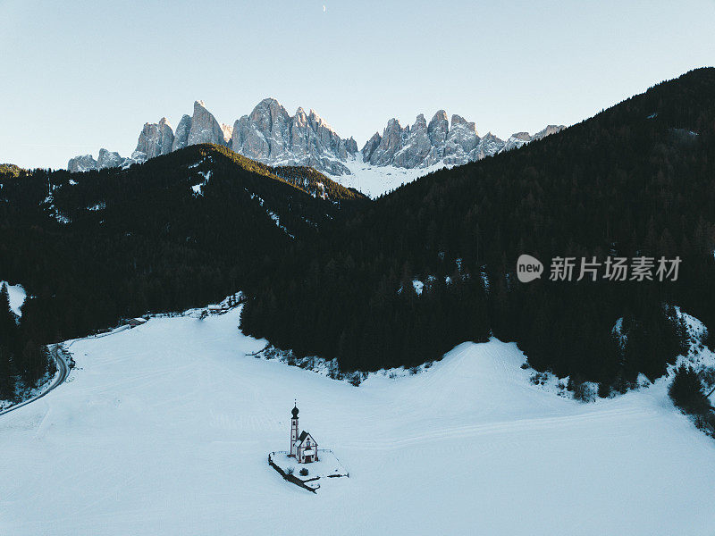 鸟瞰冬天多雪的白云石山峰和小教堂