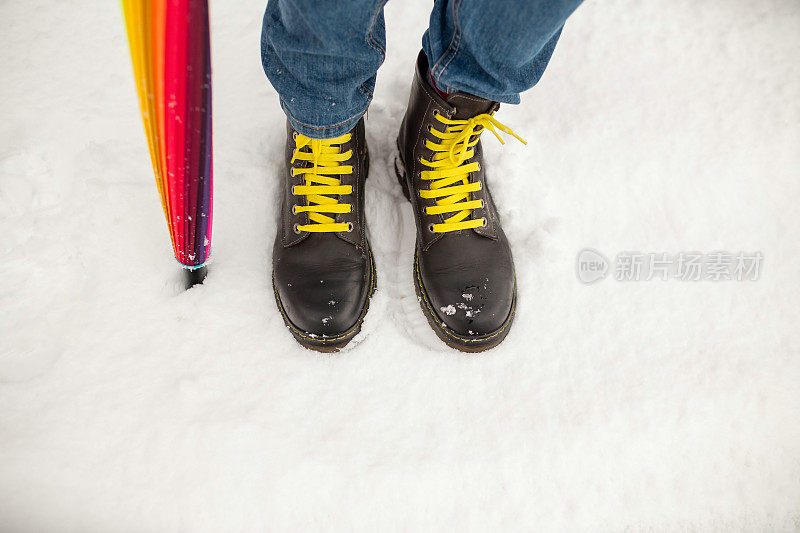 腿女人冬天棕色毛皮靴子走在雪地上近距离保暖靴子的大底。